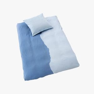 Comfortable blue and white bedding set with pillow for a cozy bedroom.